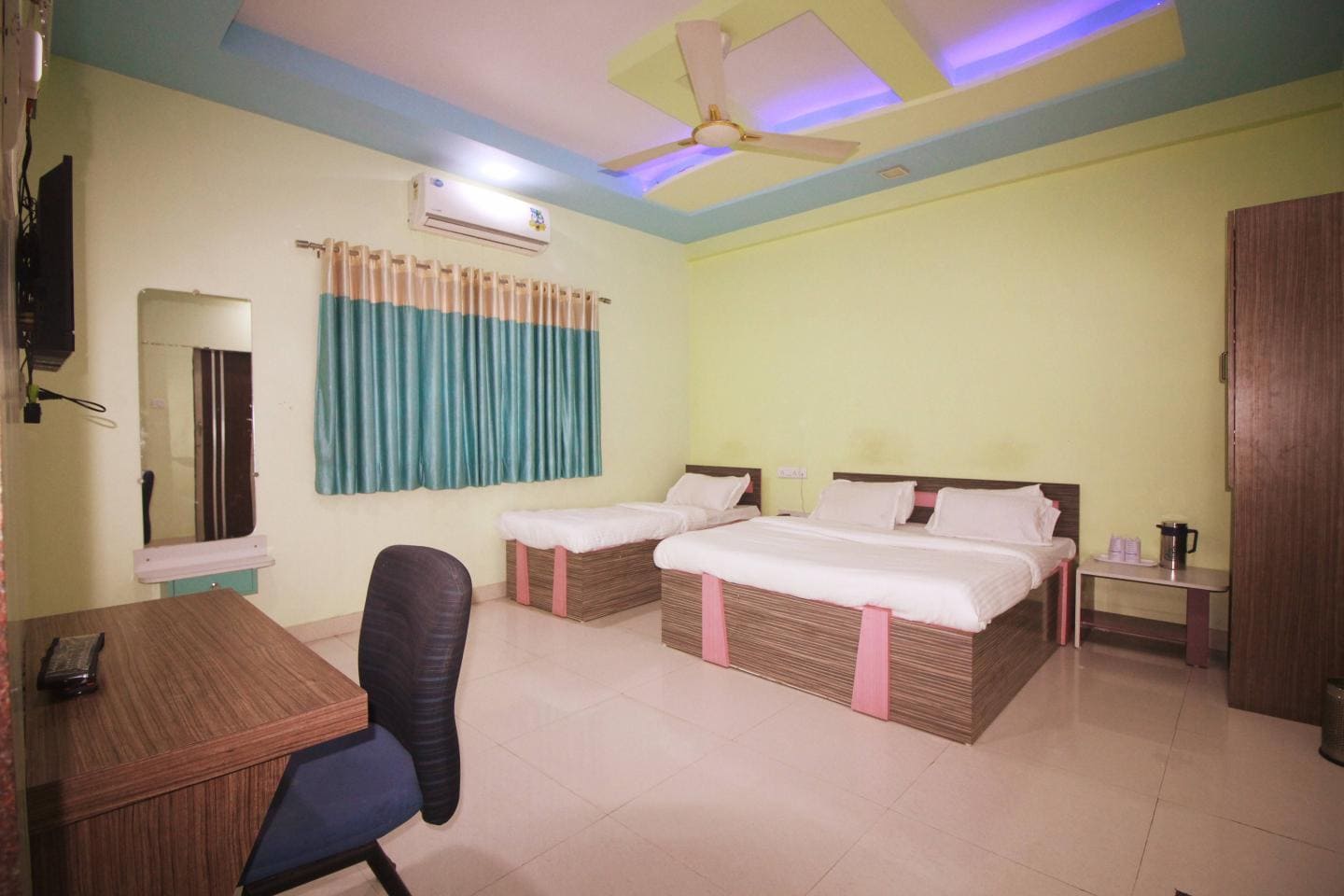 Comfortable sleeping arrangements in Hotel Somnath Sagar's Veraval triple bed room, featuring three individual beds with clean linens.